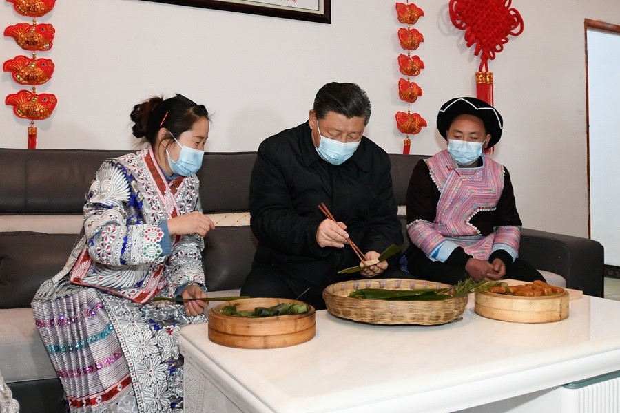 2021年2月3日下午，習(xí)近平在貴州畢節(jié)市黔西縣新仁苗族鄉(xiāng)化屋村苗族村民趙玉學(xué)家，同一家人邊聊家常邊制作當(dāng)?shù)貍鹘y(tǒng)節(jié)日食品黃粑。新華社記者 李學(xué)仁 攝