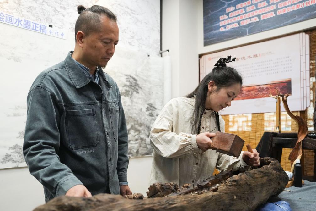 潘能輝和妻子胡美華在湖南常德河街展示木雕。新華社記者 薛宇舸 攝